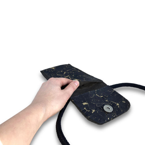 KEDJA deluxe Umhängetasche in anthrazit-schwarz mit Sicht auf das geöffnete Fach und Hand, ideal für Samsung Galaxy A17