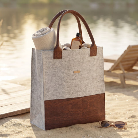 Elegante Filz Shopper Tasche mit braunem Korkelement am Strand, nachhaltige Premium Tasche von SmukBird im warmen Sommerlicht